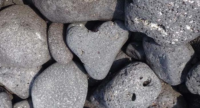 A heart-shaped rock sits in the middle of a rock pile.