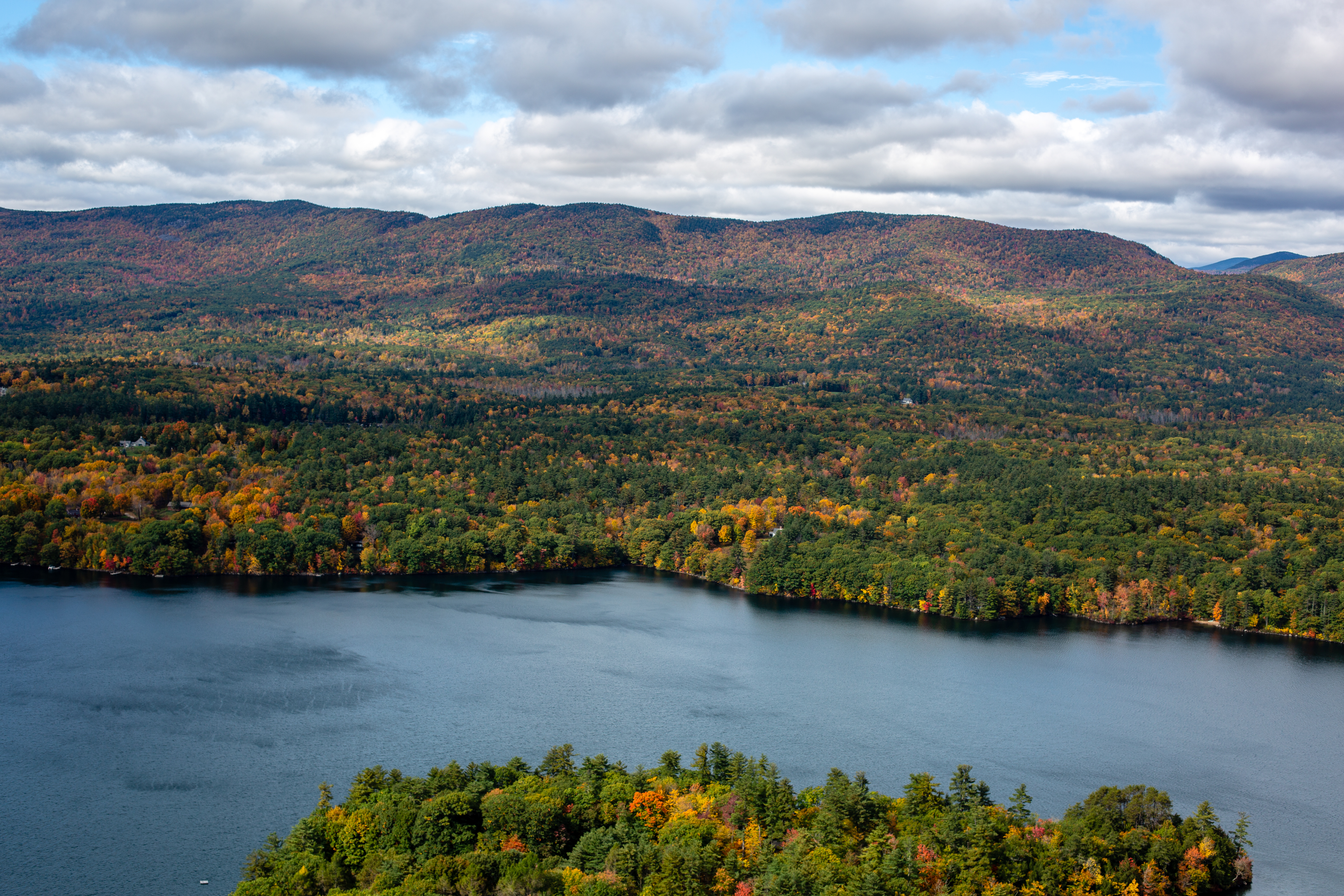 A view from Eagle Cliff of autumn foliage among hills and mountains in the distance.