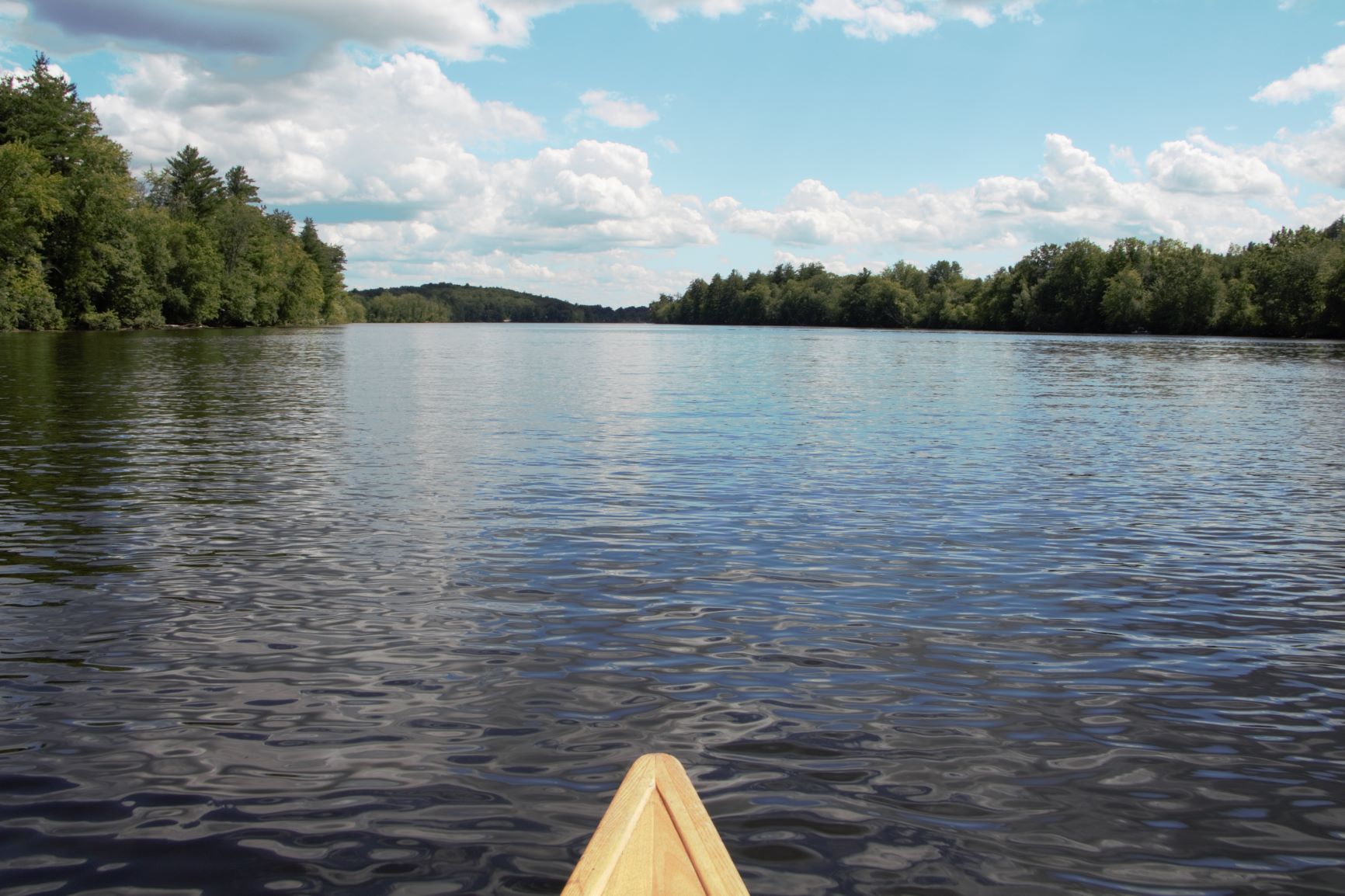 The bow of a canoe with the Merrimack River ahead.