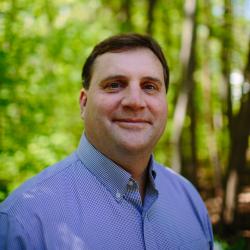 Brian Hotz poses in the forest outside of the Conservation Center.