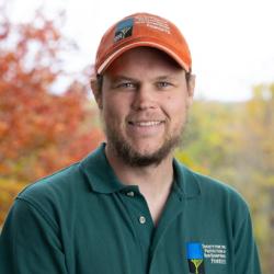 Cameron Larnerd poses outside on the deck of the Conservation Center in autumn.