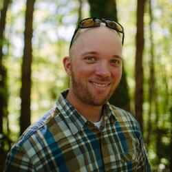 Ryan Smith poses in front of trees near the Conservation Center.