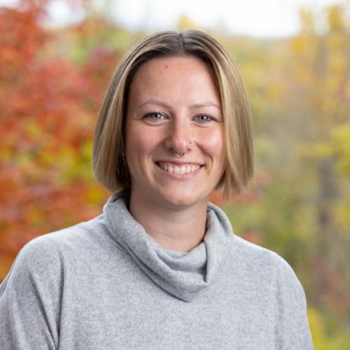 Brie Morshead poses outside on the deck of the Conservation Center in autumn.