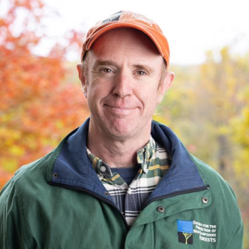 Frank Allen poses outside on the deck of the Conservation Center in autumn.