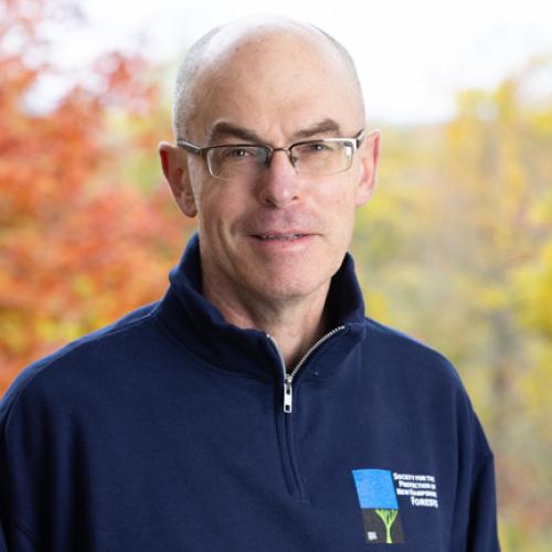 Matt Leahy poses outside on the deck of the Conservation Center in autumn.