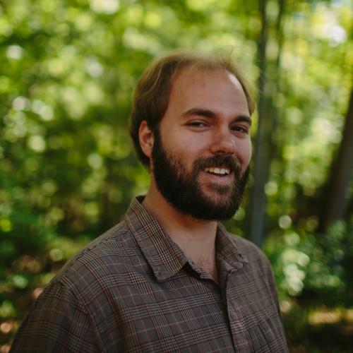 Matt Scaccia poses in the woods outside the Conservation Center.