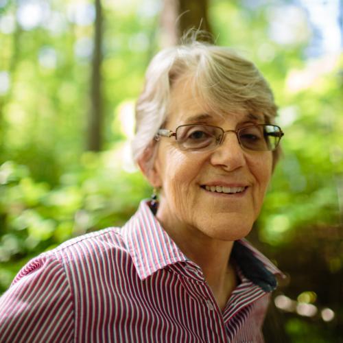 Susanne Kibler-Hacker poses in the forest outside of the Conservation Center.