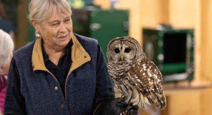 A volunteer holds a barred owl ambassador.