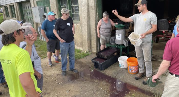 Bill Kunelius shows a seed to the volunteers.