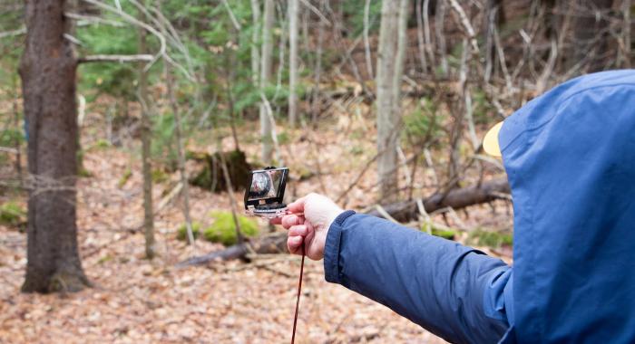 Person holding up compass in the forest