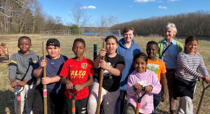 Students pose with shovels after planting trees