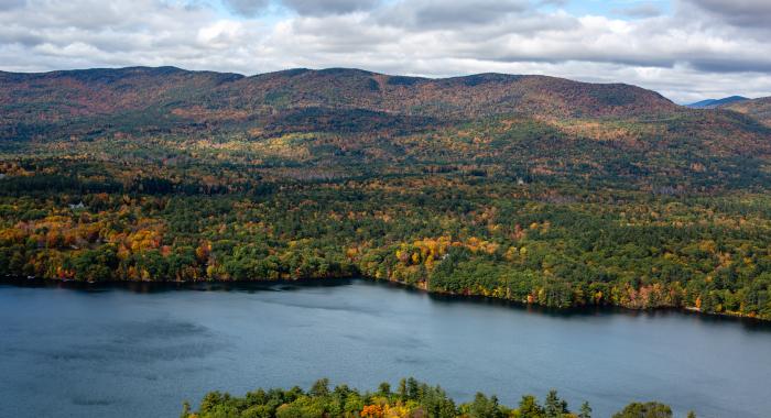 A view from Eagle Cliff of autumn foliage among hills and mountains in the distance.