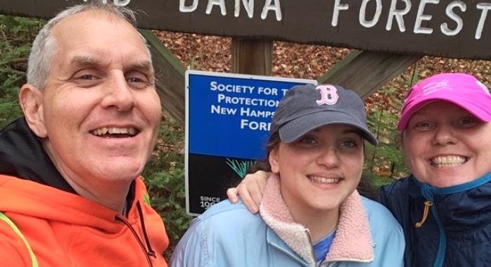 Scott Casper and his family pose by a Forest Society sign at Dana Forest during the 2020 5 Hikes Challenge.