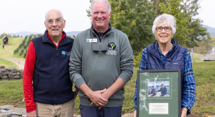 Tim and Midge Eliassen pose with their award with Christmas tree fields in the background.