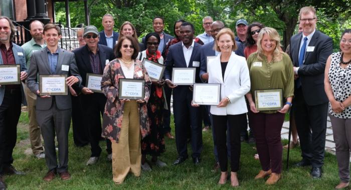 Recipients stand holding their certificates.