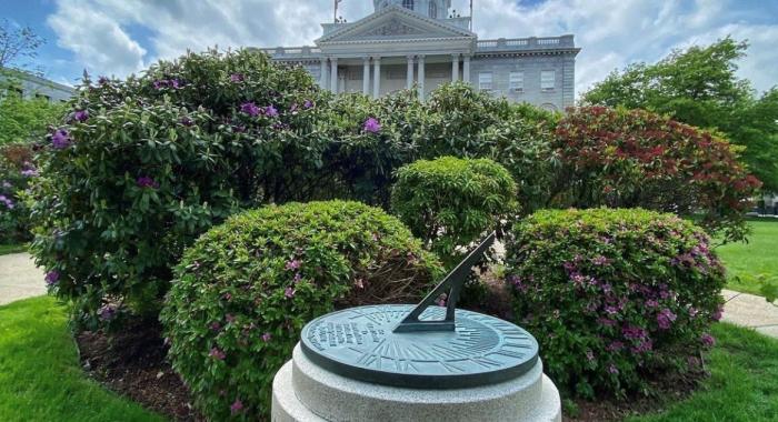 NH State House under a blue sky with wispy clouds