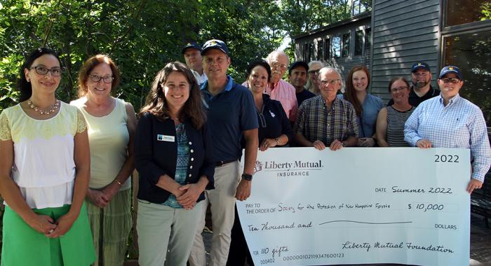 Representatives of the Forest Society and Liberty Mutual pose with a giant check. (Photo: Anna Berry)