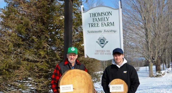Tom Thomson owner of the Thomson Family Tree Farm with grandson Jaden Thomson. Both are holding tree "cookies' in front of a sign for Thomson Tree Farm. (Courtesy of Tom Thomson)