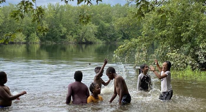 Kids splash in the Merrimack River on a hot day.