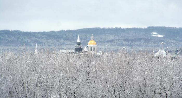 NH State House dome seen from Conservation Center in winter covered in snow.