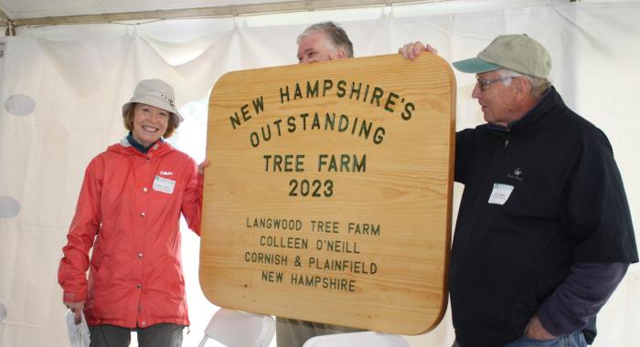 Colleen O'Neill accepts the large wooden sign at the event.