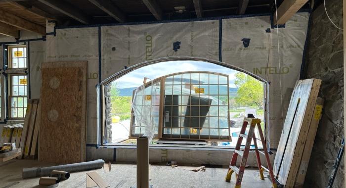 A large window is loaded into the space that used to serve as the arched gate of the barn.