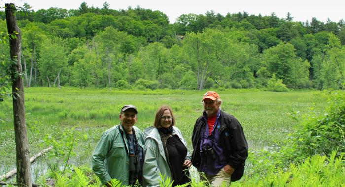 The team sits on a bench on the floodplain in spring.