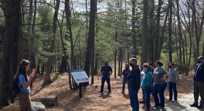 field trip participants masked and distanced stand along Lovewell Pond