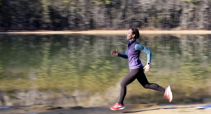 Woman running along trail next to water