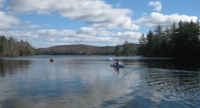 Two Kayakers on lake with fall hills in background