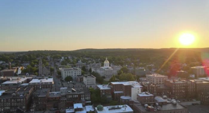 Sunrise over downtown Concord rooftops and State House Capitol dome