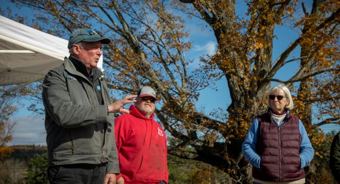 President Jack Savage speaks during the closing ceremony outdoors at Morrill Farm as the owners stand next to him. 