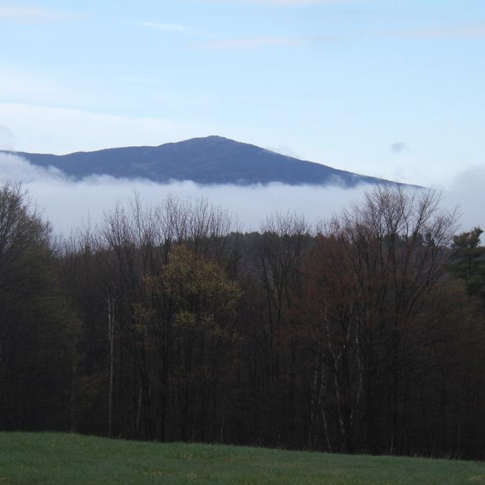 The mountain from a distance covered partially by fog.