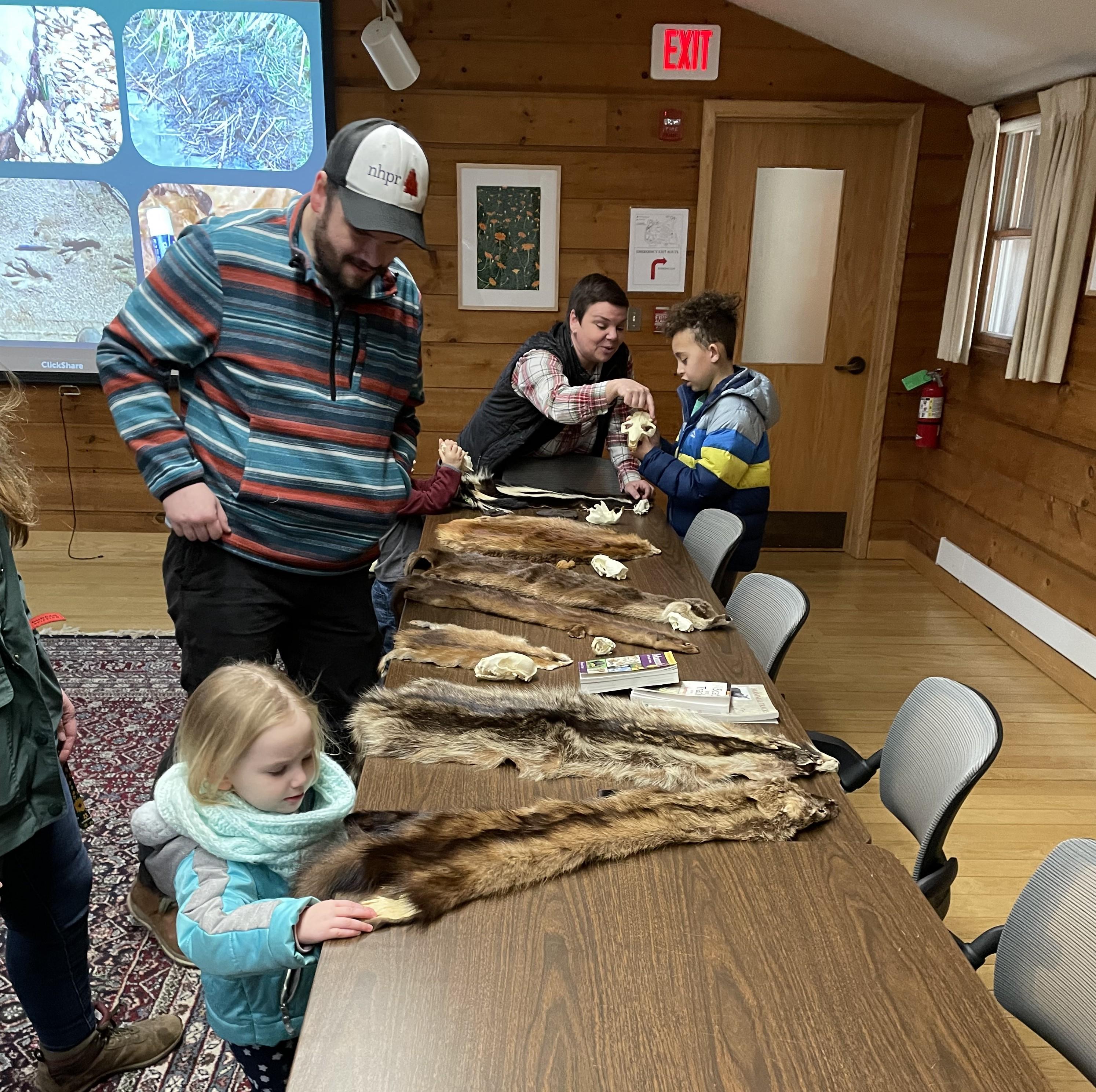 Kids look at beaver pelts during a program on beavers.