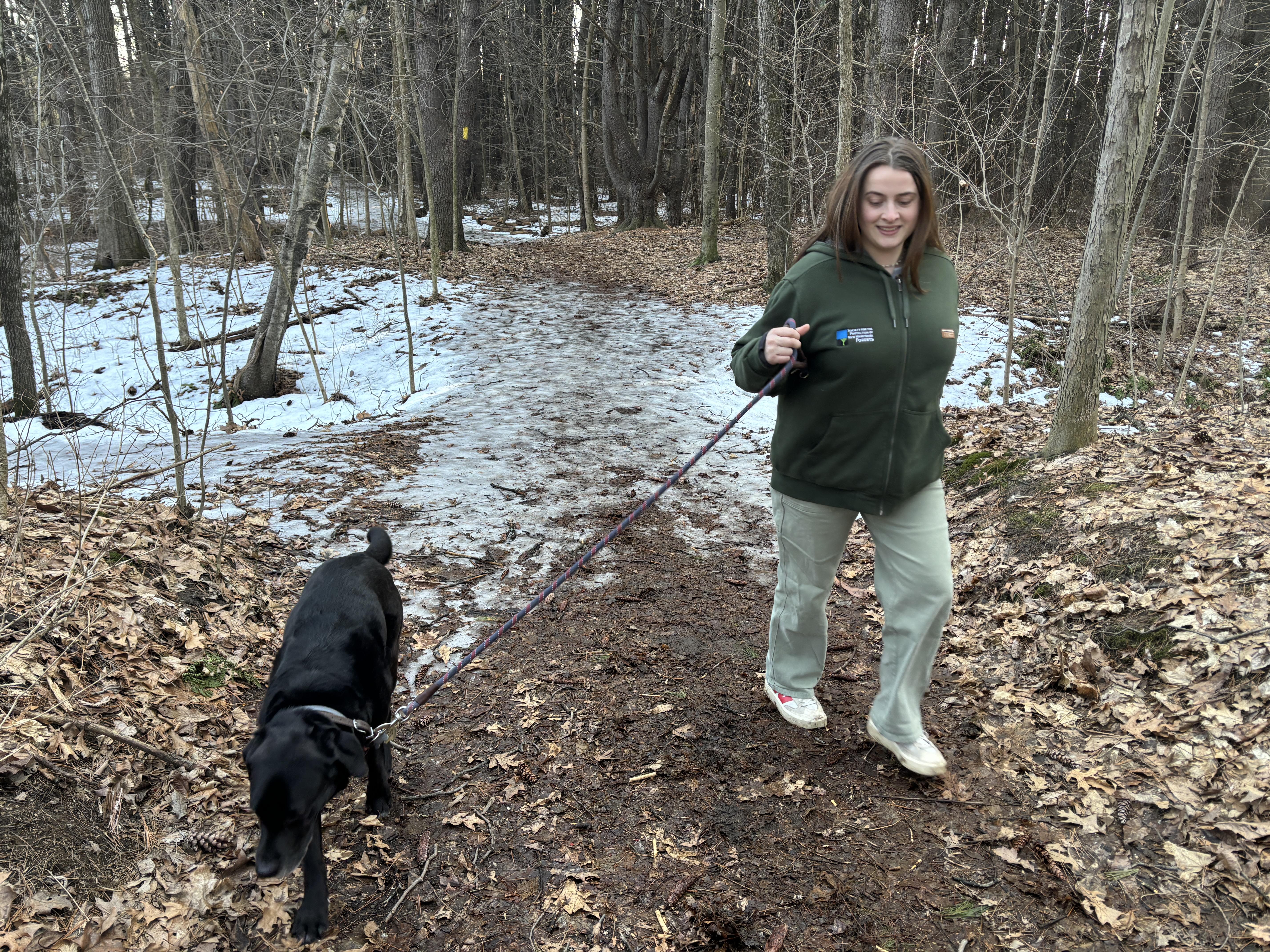 Sophie Oehler takes her dog, Auggie, for a walk on the partially frozen floodplain.