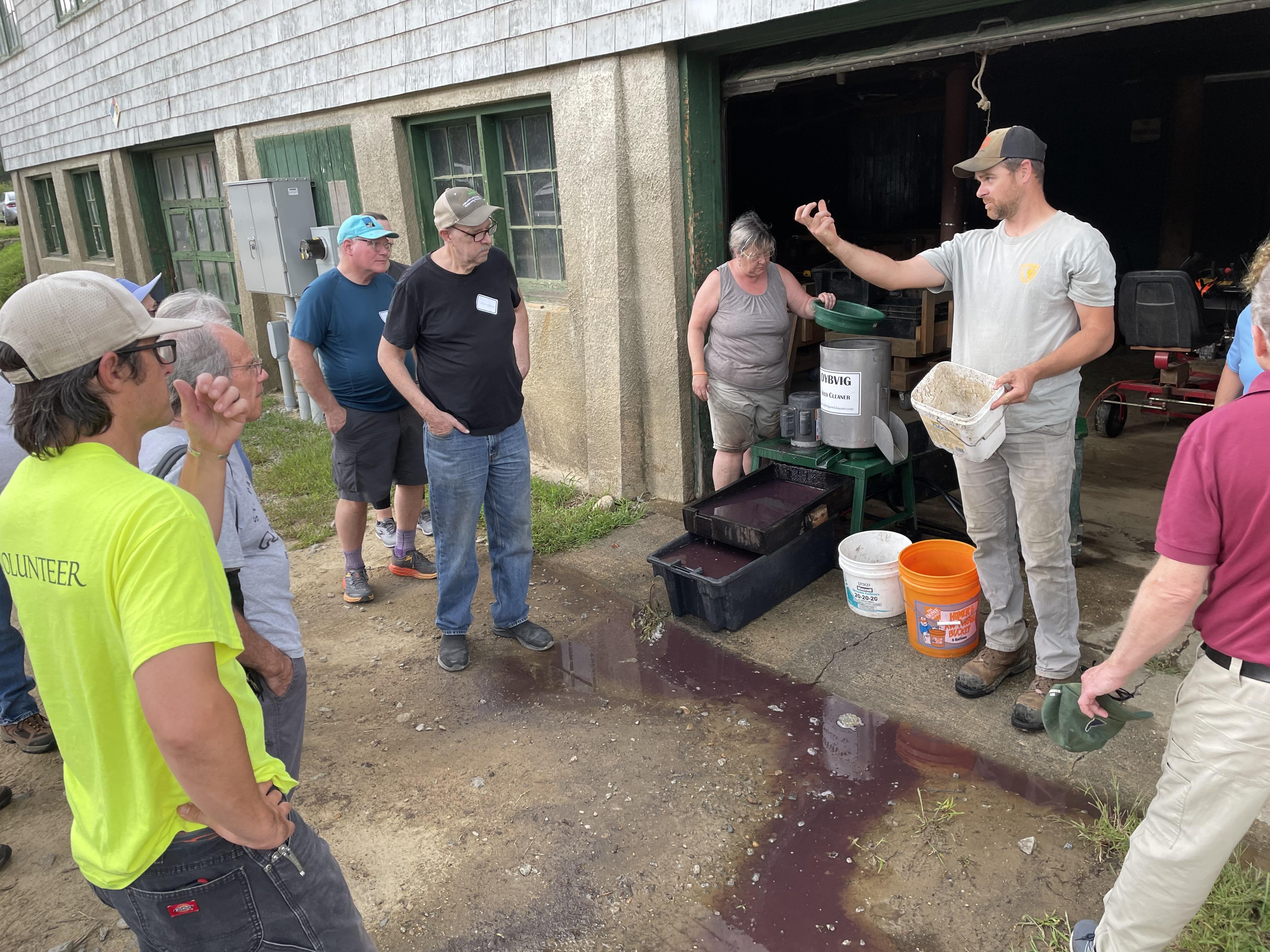 Bill Kunelius shows a seed to the volunteers.