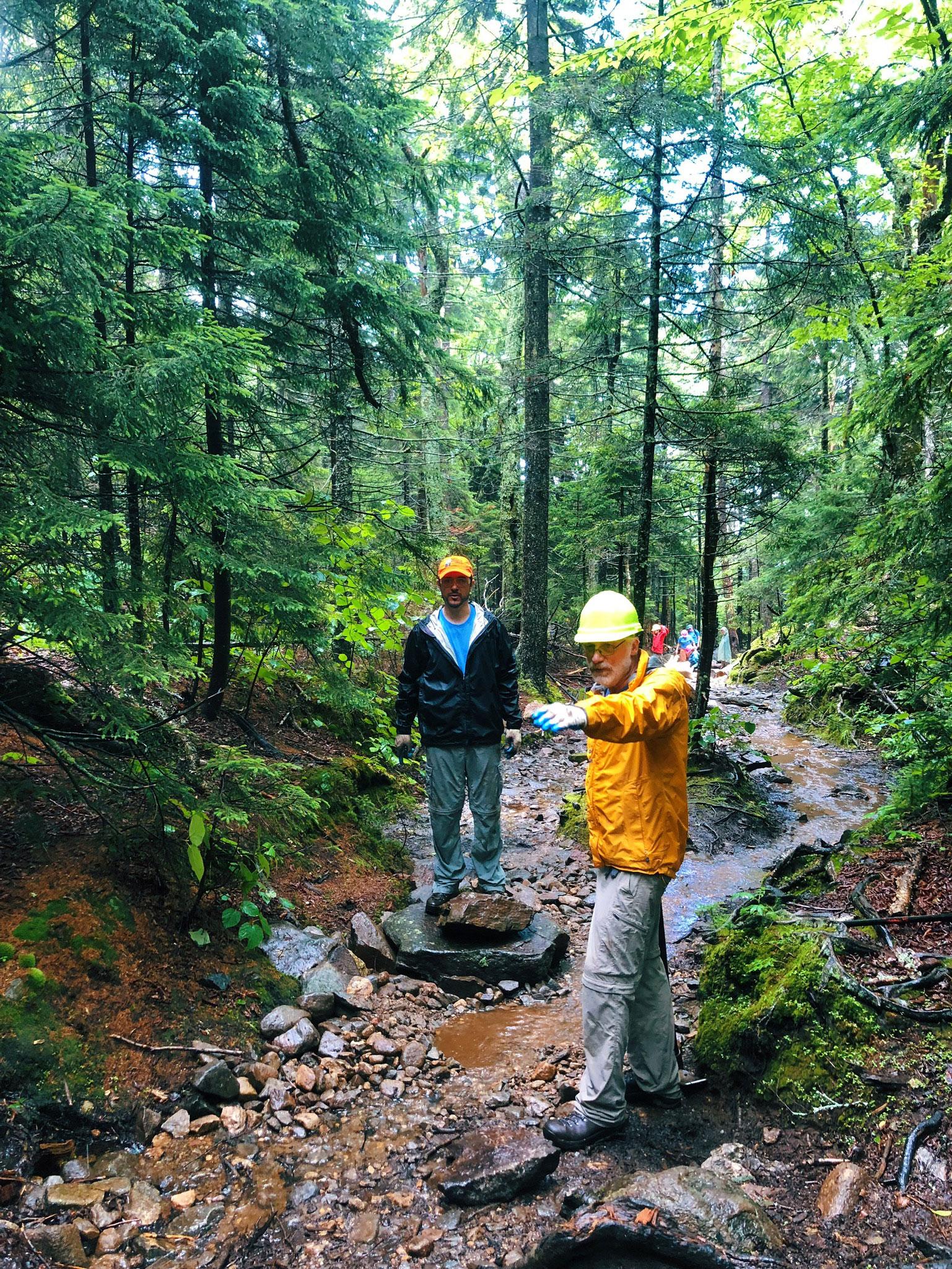 Forest Society Forester Steve Junkin and Volunteer Dave Heuss strategize where to move rocks in order to divert water around a section of the White Arrow Trail at Mount Monadnock.