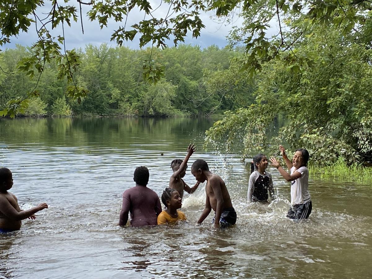Kids splash in the Merrimack River on a hot day.