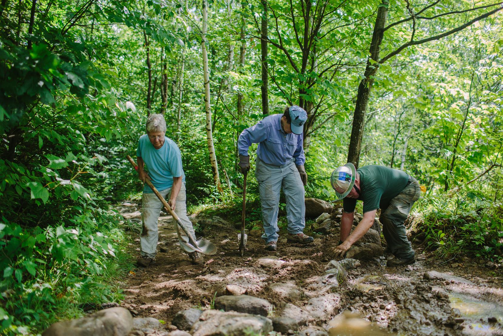 Rocks and mineral soil are used to create "waterbars" that help move water off the trail