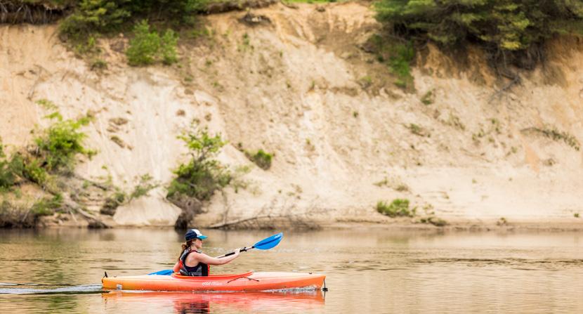 A kayaker paddles alongside Stillhouse Forest in Canterbury, New Hampshire