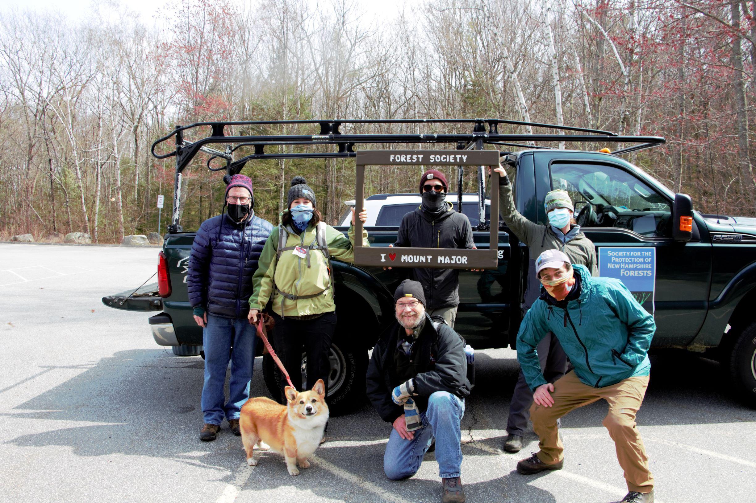 Forest Society staff and volunteers pose in the parking lot at Mt Major with a truck full of collected trash behind them.