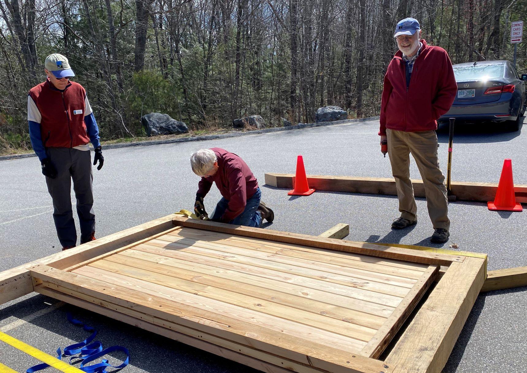 Volunteers ready a information wall to be attached to the covered pavilion.
