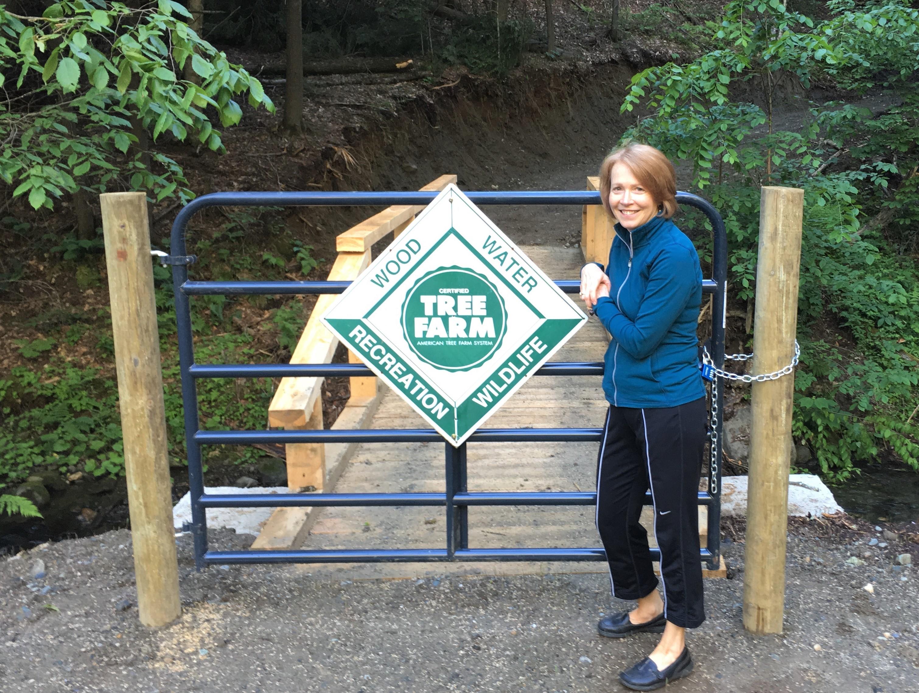 Colleen stands near a bridge on her property.
