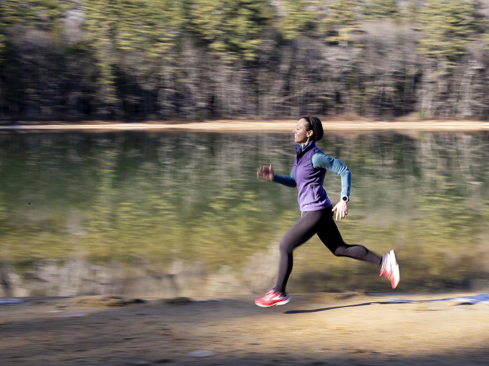 Woman running along trail next to water