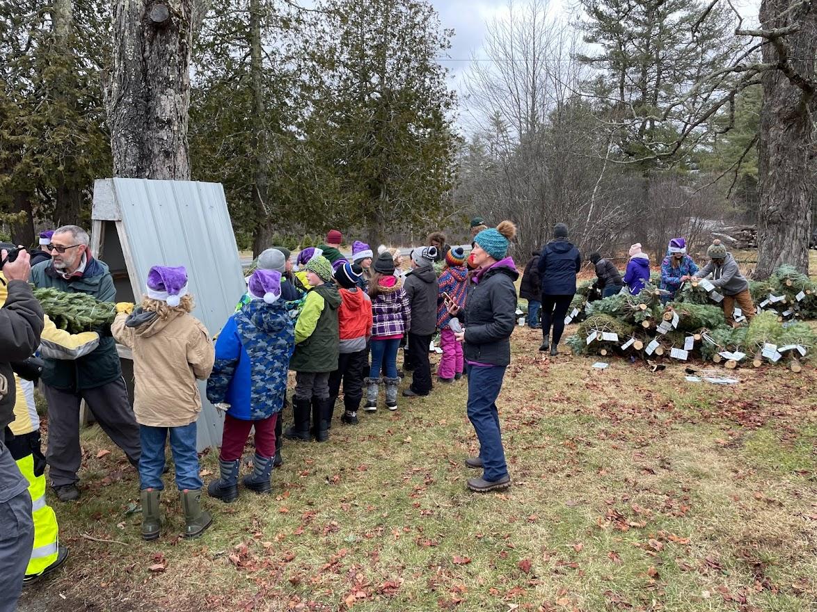 Students pass trees to be loaded into a FedEx truck.
