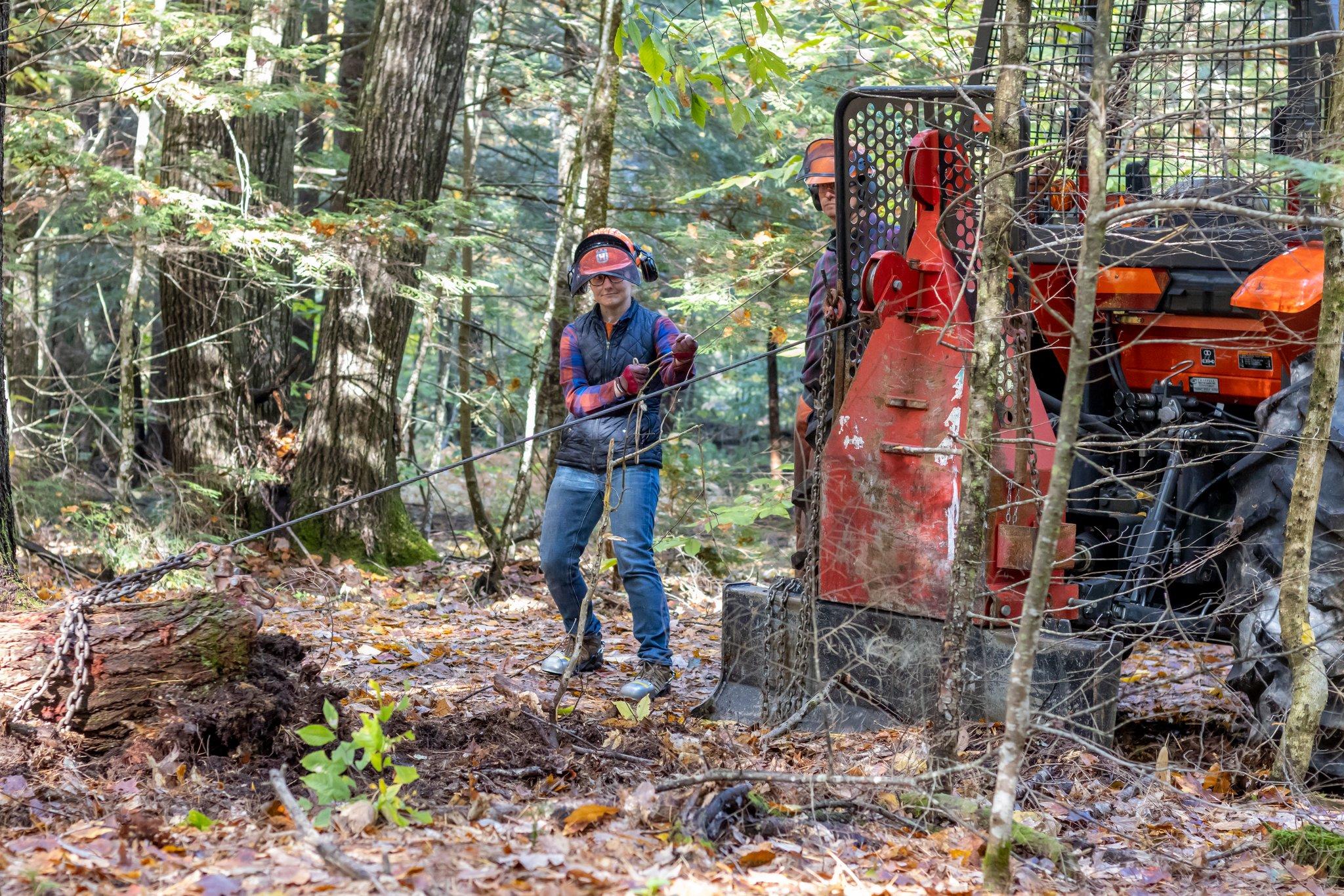 A participant practices technique for lifting a log while another drives the tractor.