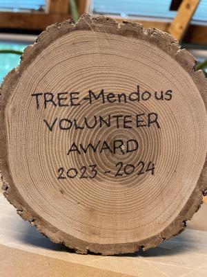 A tree cookie with the words "TREE-mendous Volunteer Awared 2023-2024" etched on the face.