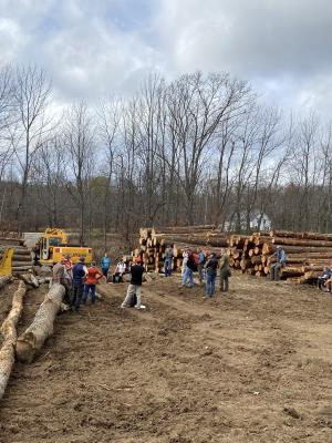 people at log landing with yard loader