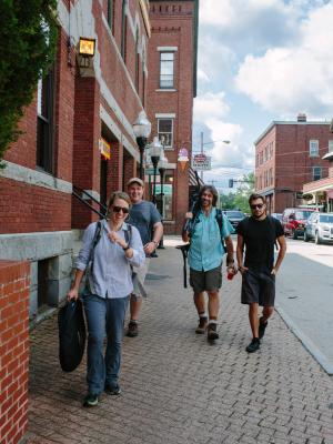 Four members of the crew of the film walk down a street in Portsmouth with their equipment.