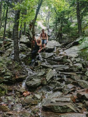 Hikers descend a dangerously slippery White Arrow trail at Monadnock State Park after heavy rain converted the path into a waterfall in July 2018.